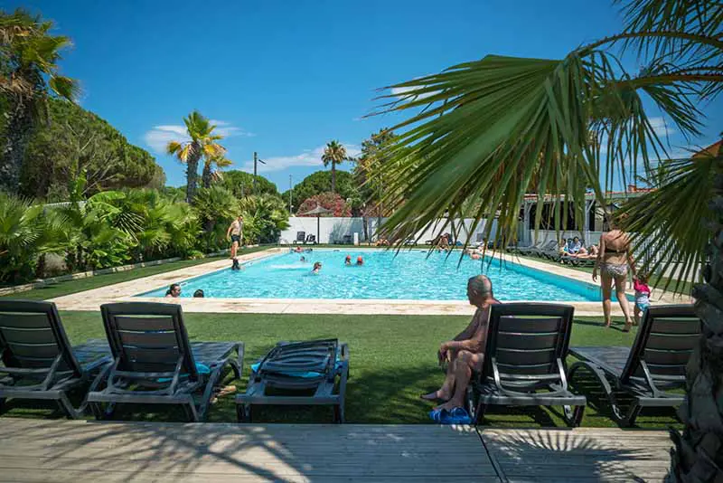 Piscine chauffé avec des transats et des enfants dedans